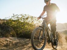 a man riding a bike down a dirt road